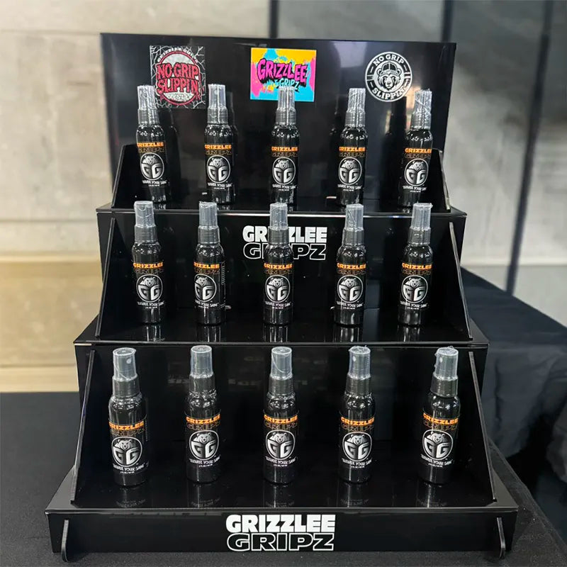 Dynamic display image of Grizzlee Gripz Tacky anti-slip grip spray bottle in a 2025 tournament facility, featuring the sleek black bottle amid sports settings with highlighted benefits: enhanced tacky anti-slip grip, instant boost for tournament play, sweat resistant performance, versatile for multiple sports events, long-lasting formula for extended use, no chalky mess or silicone residue, and player-controlled tackiness. Perfect for athletes in competitive facility environments 