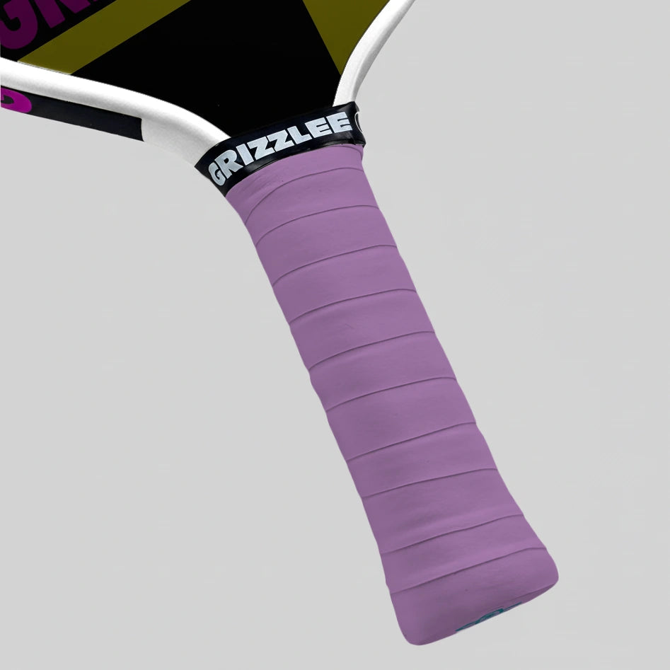 Close-up of a light purple pickleball paddle overgrip with 'Grizzlee Gripz' branding on a gray background