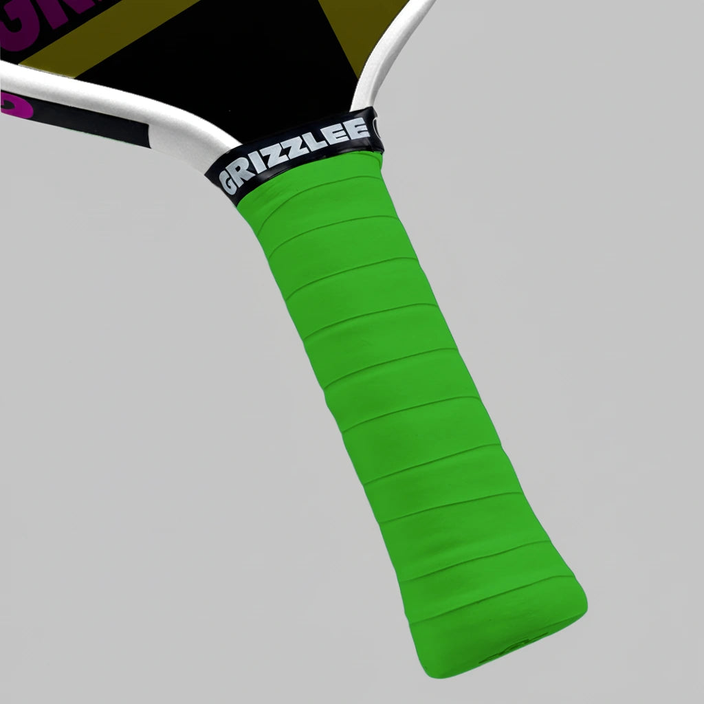 Close-up of a lime green pickleball paddle overgrip with 'Grizzlee Gripz' branding on a gray background