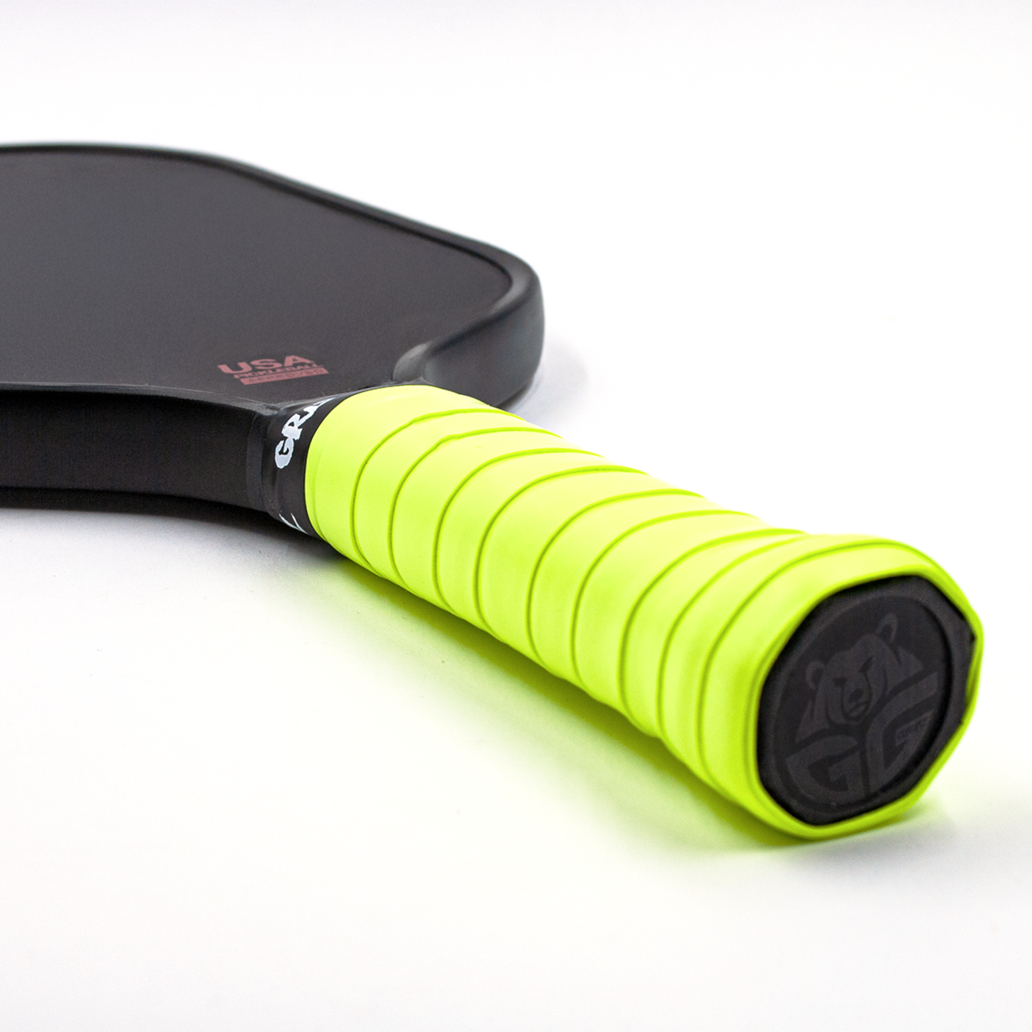 Neon Green Grizzlee Gripz wrapped on a paddle handle that laying flat - Premium Pickleball Overgrip by Grizzlee Gripz