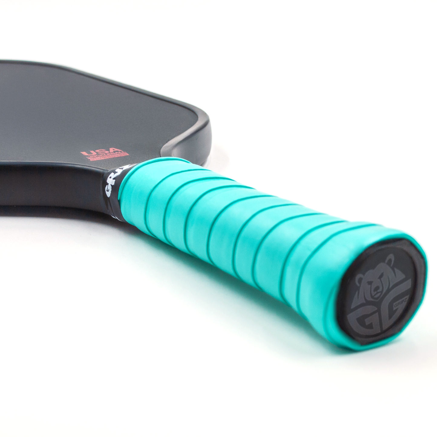 sapphire green grizzlee gripz overgrips wrapped on a paddle handle thats laying down - Premium Pickleball Overgrip by Grizzlee Gripz