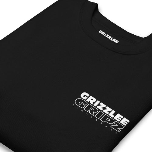 mockup of folded black crewneck with inside label in white font - Premium Pickleball Overgrip by Grizzlee Gripz